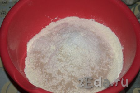 В достаточно объёмную миску насыпаем муку, сухие дрожжи, соль, сахар и тщательно перемешиваем мучную смесь ложкой.