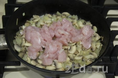 Куриное филе нарезать на кубики и добавить в сковороду к луку и грибам, перемешать.