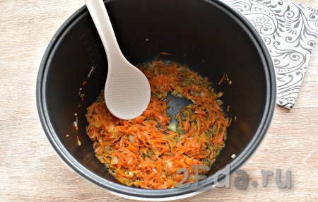 Наливаем в съёмную чашу мультиварки 60 мл растительного масла, затем выкладываем лук с морковкой и включаем режим «Жарка». Обжариваем овощи, не прикрывая крышкой, в течение 10 минут, периодически перемешивая. 