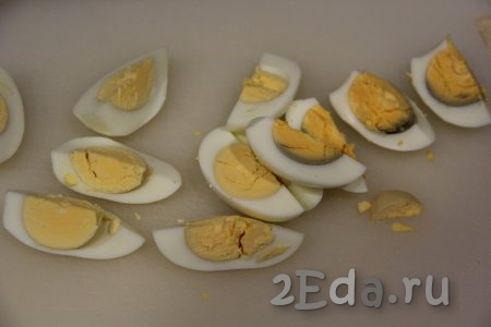 Почистить варёные яйца и нарезать на крупные дольки.