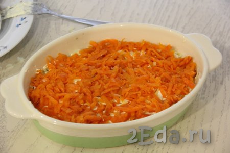 Следующим слоем равномерно выложить очищенную и натёртую варёную морковку.