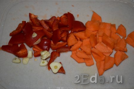 Далее чистим морковь, из болгарского перца удаляем семена и плодоножку. Нарезаем перец и морковку на кусочки (очень мелко нарезать не нужно). Два зубчика чеснока очищаем и нарезаем на пластины.