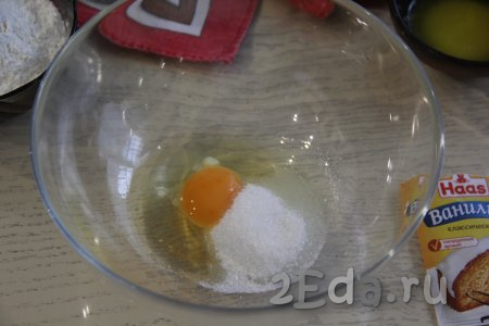 Пока яблоки карамелизируются, замесим тесто, для этого в достаточно объёмной миске нужно соединить яйцо, ванилин и сахар, перемешать венчиком.