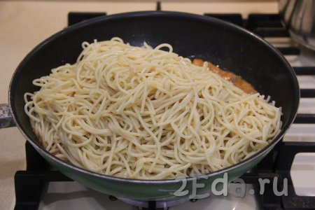 Добавить спагетти в сковороду к куриному филе с грибами.