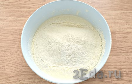 В получившуюся яично-масляную смесь просеиваем пшеничную муку и всыпаем разрыхлитель для теста.