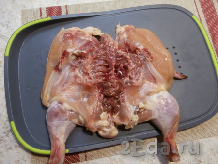 Цыплёнка вымыть, разрезать вдоль по грудке, распластать его.