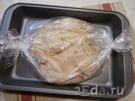Поместить тушку цыплёнка в пакет для запекания, края пакета с двух сторон хорошо перевязать и разместить на противне. В верхней части пакета сделать несколько дырочек зубочисткой, шпажкой или просто ножом. Дырочки нужны для выхода пара во время запекания.