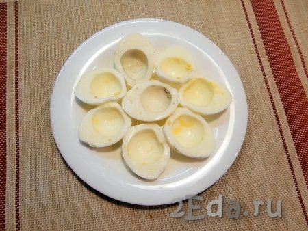 Яйца отварить в кипящей воде в течение 8-10 минут, а затем полностью охладить их и очистить. Разрезать яйца пополам, вынуть желтки.