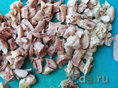 ​​​Варёную курицу отделить от костей и нарезать мякоть кубиками. Кости выкинуть, а нарезанную мякоть отложить до готовности супа.