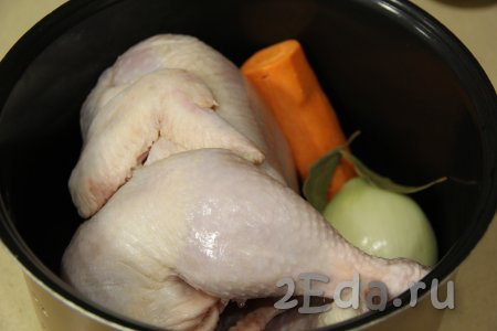 В чашу мультиварки выложить курицу целиком, добавить лук и морковь, лавровый лист и перец. Влить воду.