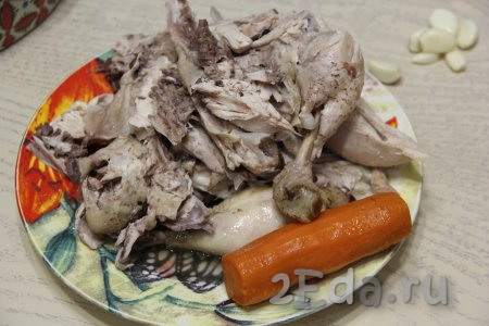 Переложить курицу на тарелку и слегка остудить. Отваренный лук выкинуть, а морковку отложить, она нам понадобится в конце для украшения холодца.
