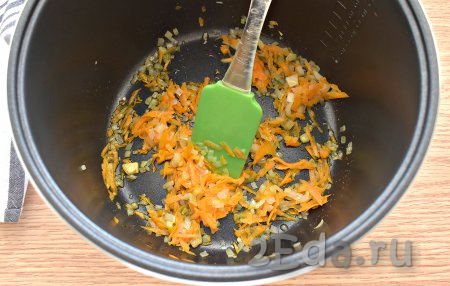 Очищаем морковку и лук. Морковь натираем на тёрке, лук нарезаем на небольшие кусочки. Включаем на мультиварке режим «Жарка». Вливаем в чашу пару столовых ложек растительного масла. Выкладываем в прогретое масло измельчённые морковку с луком и обжариваем их без крышки 5 минут. Периодически ингредиенты перемешиваем.