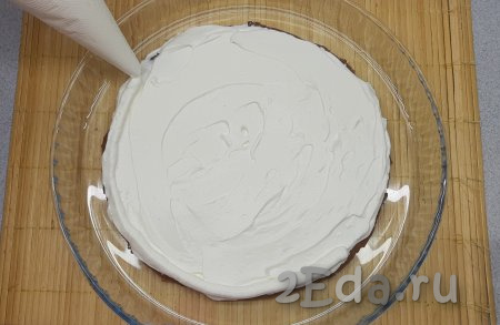 Теперь собираю торт. Первый корж выкладываю на тарелку для подачи, покрываю его слоем крема и при помощи кондитерского мешка отсаживаю по кругу небольшой бортик из крема, который и будет держать клубничный конфи.