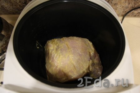 В чашу мультиварки влить растительное масло и выставить режим "Жарка". Выложить подготовленный кусок свинины.