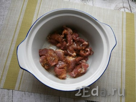Нарезать мякоть свинины на небольшие кусочки, выложить в форму (или кастрюлю), предназначенную для готовки в духовке. Посолить мясо, посыпать приправой, влить растительное масло.