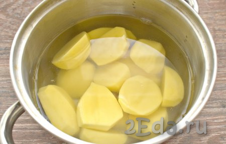 Очищенную картошку разрезаем пополам, перекладываем в кастрюлю и полностью заливаем водой. Сразу картофель солим по вкусу. После закипания отвариваем картошку на небольшом огне до готовности. У меня ушло на отваривание 25 минут.