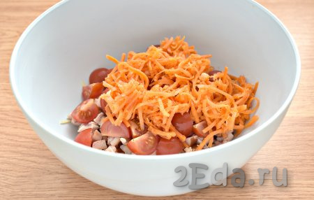 Морковку по-корейски отжимаем от маринада. Очень длинные полоски можно разрезать на 2-3 части. Добавляем корейскую морковь в салат из помидоров, копчёной курицы и сыра.
