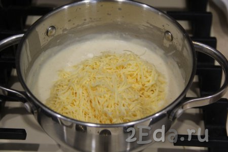 На медленном огне, помешивая, довести соус до кипения. Сыр натереть на мелкой тёрке и добавить в кастрюлю.