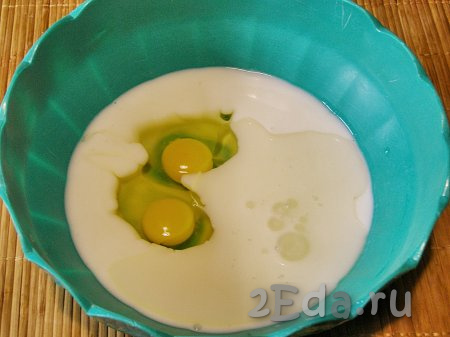 В глубокую миску переливаем кефир, вбиваем яйца и добавляем 2 столовые ложки подсолнечного масла без запаха, перемешиваем кефирно-яичную смесь венчиком до однородности.