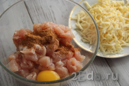 К кусочкам куриного мяса добавить соль, яйцо и специи.