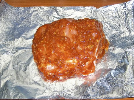Обмазываем приготовленным томатным соусом кусок мяса со всех сторон и заворачиваем его в фольгу. Края фольги должны быть сверху, чтобы во время запекания не вытекал сок. Убираем мясо в холодильник на 3-4 часа. Для надёжности можно завернуть свинину в два слоя фольги.