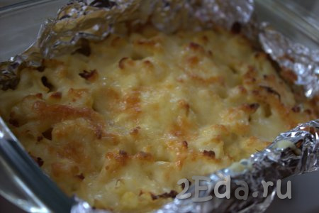 Цветную капусту, запечённую с картошкой под сырной корочкой, можно доставать из духовки и раскладывать по тарелкам.
