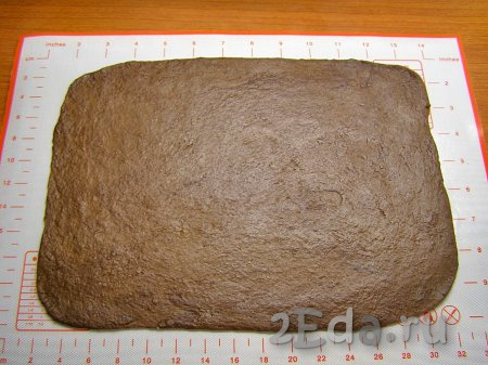 Шоколадное тесто на слегка присыпанной мукой поверхности раскатываем в прямоугольник размером, примерно, 22 сантиметра на 28 сантиметров и толщиной около 3 миллиметров.