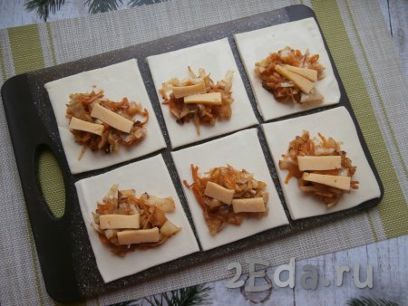 В середину каждого квадрата выложить по 1-2 столовых ложки капусты. По желанию, к капустной начинке можно добавить по два кусочка твёрдого сыра.