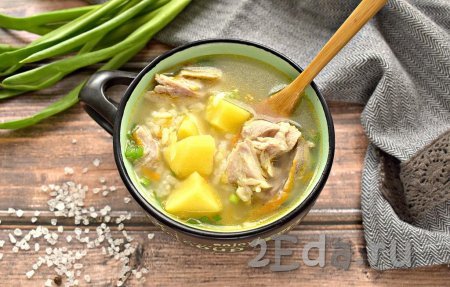 Вкусный, наваристый рисовый суп, приготовленный со свининой и картошкой, разливаем по тарелкам и подаём горячим на стол.