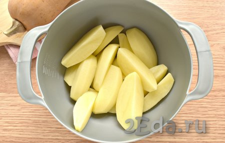 Очищаем и нарезаем картофель на крупные ломтики, перекладываем в глубокую миску.