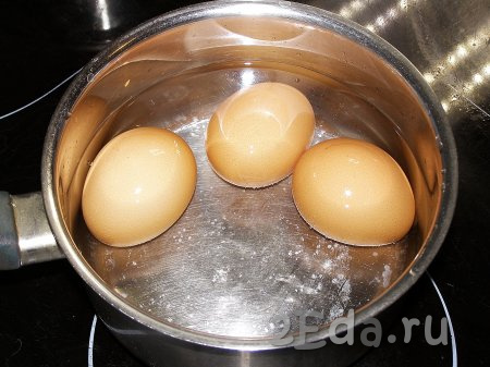 Сначала отварим 3 яйца, которые станут начинкой для рулета, для этого их моем, перекладываем в сотейник (или небольшую кастрюльку), заливаем полностью холодной водой, ставим на огонь и после закипания варим 8-10 минут. Затем охлаждаем яйца под холодной водой и очищаем от скорлупы.