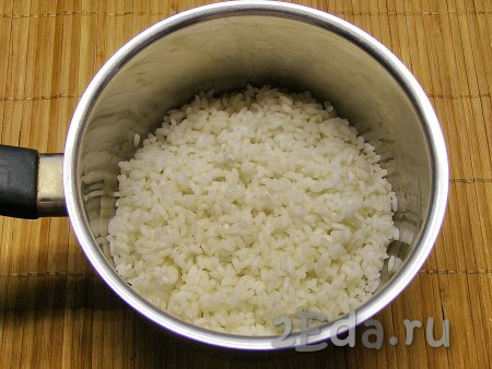Рис промываем несколько раз. В достаточно большое количество кипящей, слегка подсоленной воды выкладываем промытый рис, даём закипеть воде, а затем  отвариваем рис до полуготовности (на это потребуется минут 8-10), затем сливаем воду через дуршлаг. Оставляем рис остывать. Промывать отваренный рис не надо, иначе он потеряет клейкость и тефтели могут развалиться.