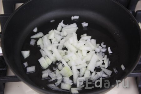Влить в сковороду растительное масло, выложить мелко нарезанную луковицу и обжаривать до золотистости, иногда перемешивая, на среднем огне.