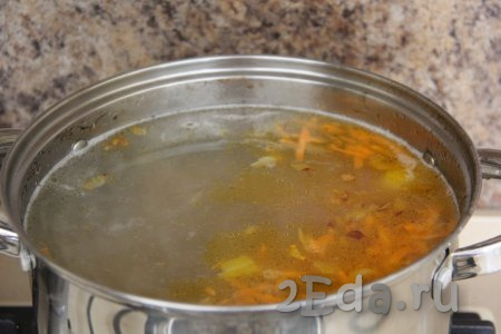 Затем в суп из утиных крыльев и картошки выложить обжаренные овощи, довести до кипения.