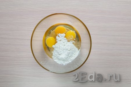 Смешайте в объёмной миске куриные яйца, соль, сахар, влейте 2 столовые ложки растительного масла и начните постепенно добавлять муку. Вначале перемешивайте тесто ложкой.