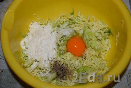 В миску перекладываем нарезанную капусту, добавляем яйцо, муку, солим и перчим.