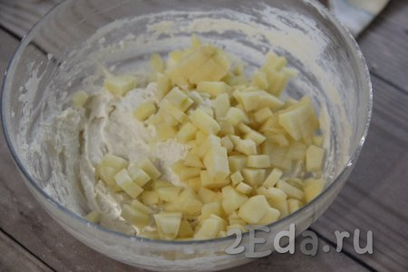 Нарезать на мелкие кубики яблоко, очищенное от кожуры и семечек. Добавить кубики яблока в творожное тесто.