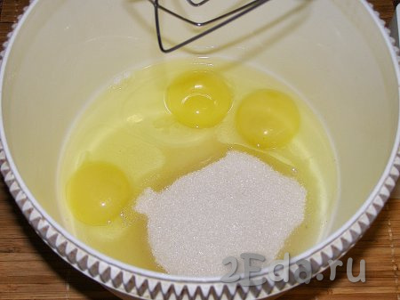 В глубокую ёмкость, в которой будет удобно взбивать миксером, разбиваем яйца, всыпаем сахар и взбиваем яично-сахарную смесь миксером, пока сахар не растворится (на это потребуется минуты 3-4). Яично-сахарная смесь посветлеет и увеличится в объёме.