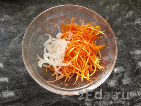 Пока огурцы просаливаются, морковку натереть на корейской тёрке в отдельную миску, добавить нарезанный тоненькими полукружочками (или перьями) репчатый лук.