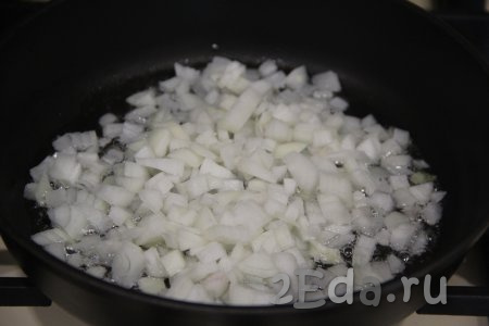 В сковороду влить растительное масло, выложить мелко нарезанную луковицу. Жарить лук около 5 минут на среднем огне, иногда помешивая.