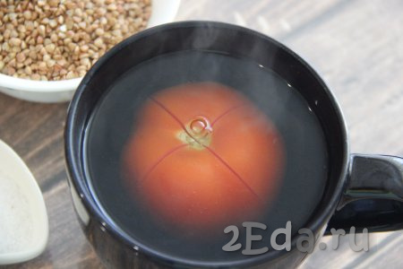 На поверхности помидора сделать крестообразный разрез и поместить его в глубокую миску. Залить помидор крутым кипятком и оставить на 5 минут.