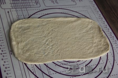 Разделить тесто на две части. Раскатать каждую часть теста на припылённой мукой поверхности в длинный прямоугольник.