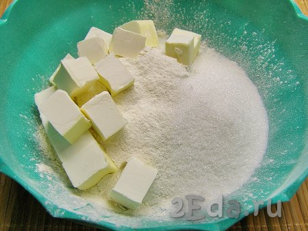 Сначала замесим песочное тесто, для этого в миску просеиваем муку, добавляем сахар и холодное сливочное масло, нарезанное на небольшие кубики. Растираем масло с мукой и сахаром руками, чтобы получилась крошка.