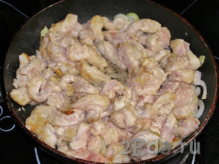 Кладём в сковородку с луком кусочки свинины, обжариваем, помешивая, 5-6 минут (до подрумянивания мяса со всех сторон).