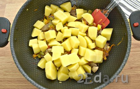  Очищенный картофель нарезаем на крупные кубики, выкладываем к свинине с овощами.