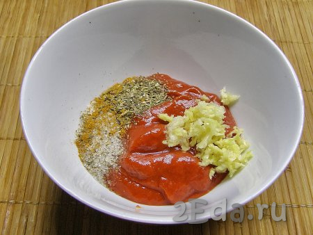 Для приготовления томатного соуса перекладываем томатную пасту в глубокую тарелку, добавляем в неё измельчённый через пресс чеснок, а также сушёную зелень, перчим и солим по вкусу. Затем добавляем холодную воду и перемешиваем до однородного состояния. Вместо томатной пасты можно использовать измельчённые блендером или мясорубкой свежие помидоры, помидоры в собственном соку, томатный соус или кетчуп, но в этом случае воды нужно будет добавить меньше. Ориентируйтесь на консистенцию соуса - он не должен быть очень жидким, но в то же время и не очень густым.