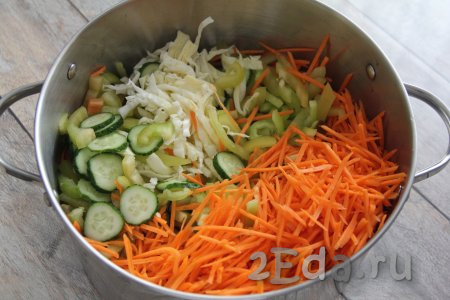 Капусту и болгарский перец нарезать на тонкие полоски. Натереть морковку на тёрке для корейской моркови (если нет такой тёрки, можно натереть морковь на крупной тёрке). Огурчики нарезать на тонкие кружочки. Соединить капусту, перец, морковь и огурцы в кастрюле, в которой будете варить салат.