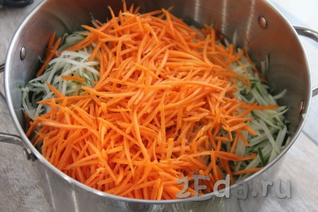 Морковь тоже натереть на корейской тёрке и отправить в кастрюлю к огурцам.