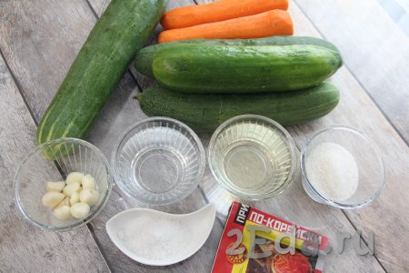 Подготовить продукты для приготовления салата из огурцов и моркови по-корейски со стерилизацией на зиму. Приправу для корейской моркови можно купить в любом магазине. Морковь и чеснок почистить, огурцы вымыть.