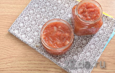 Перекладываем горячий томатный соус с луком в простерилизованные банки, накрываем прокипячёнными крышками, слегка прокручиваем.